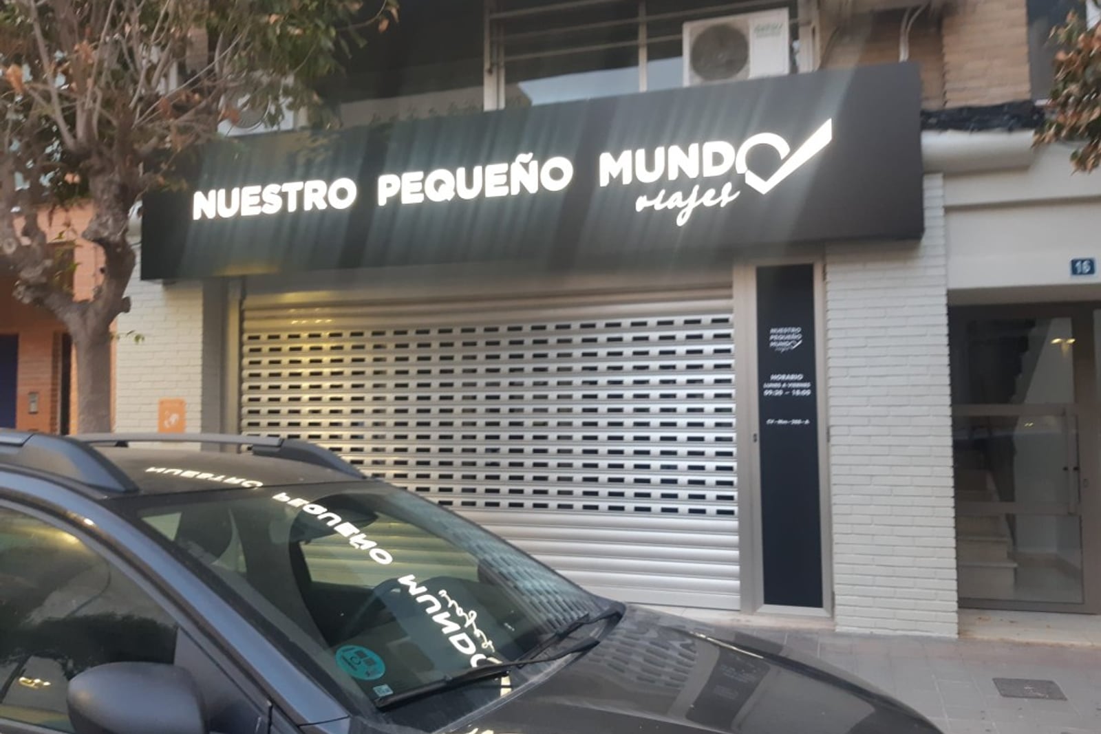 Rótulo luminoso de Nuestro Pequeño Mundo en fachada