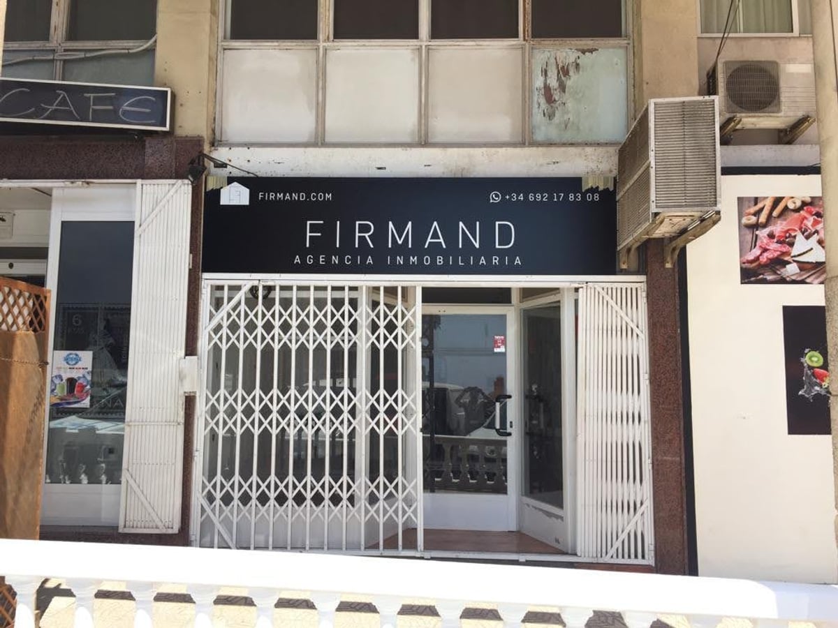 Fachada Firmand con rótulo de agencia