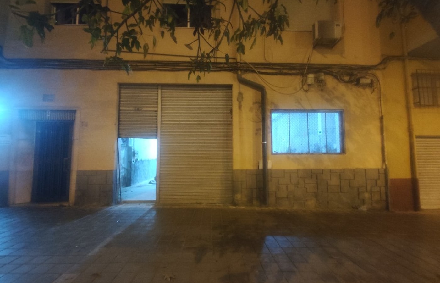Local con persiana metálica sin rotular, de noche
