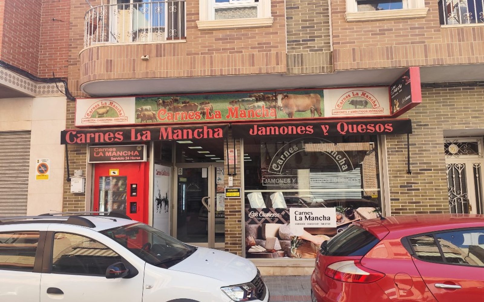 Fachada Carnes La Mancha anterior con mural de ganado y toldos